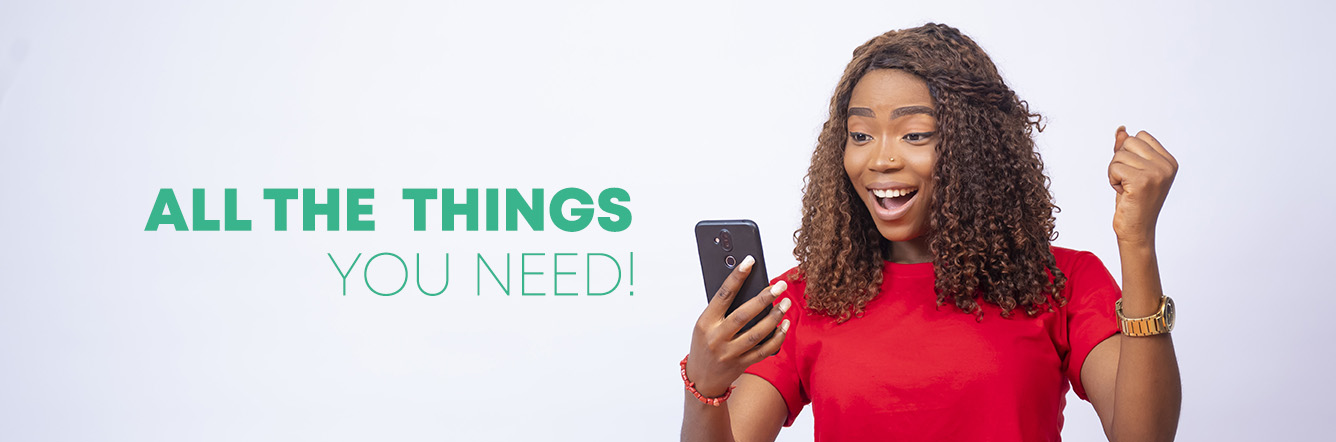 A beautiful young black woman sitting at a desk, looking at her phone and feeling excited